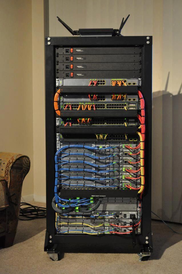 Fully populated server rack with clean cable management, patch panels, switches, and networking equipment